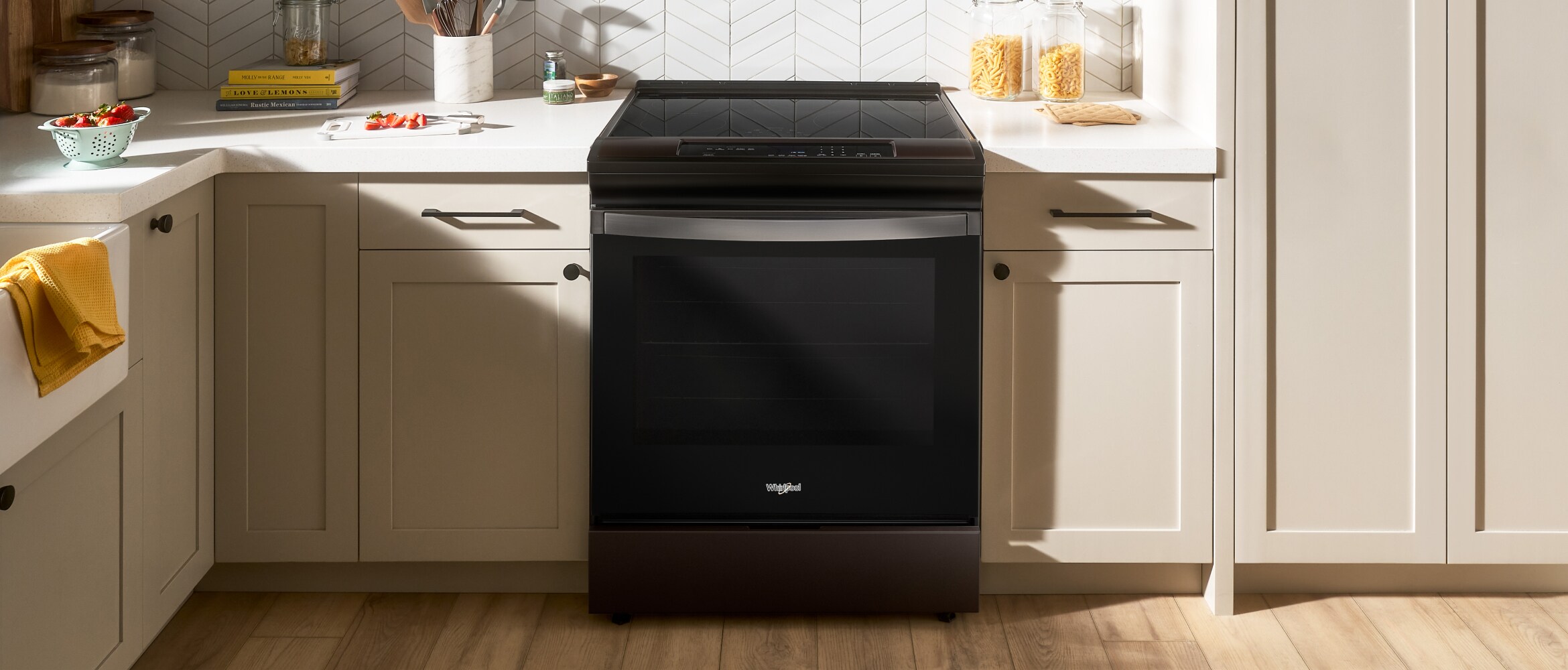 A Whirlpool® Standard Freestanding Range in a kitchen with beige cabinets