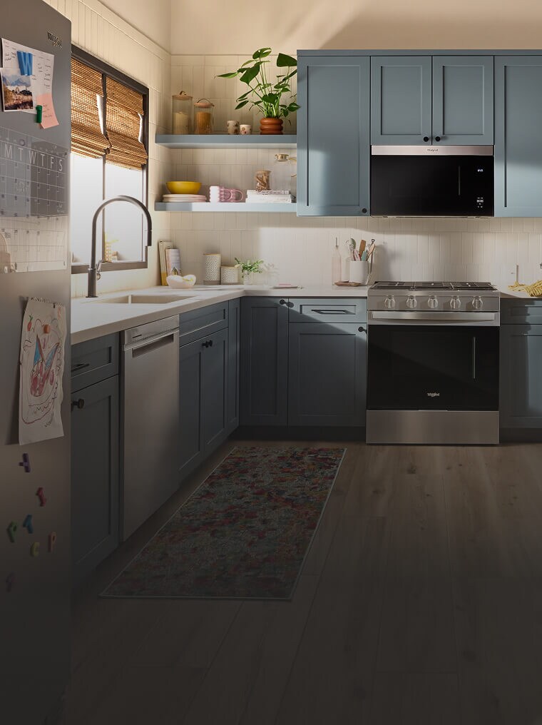 Suite of Whirlpool® appliance in a kitchen with blue cabinetry