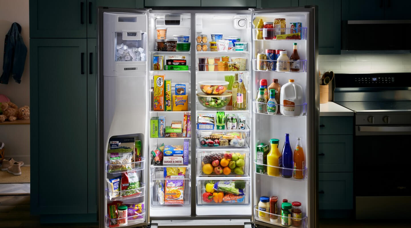 Open side-by-side refrigerator stocked with fresh and frozen foods Open side-by-side refrigerator stocked with fresh and frozen foods