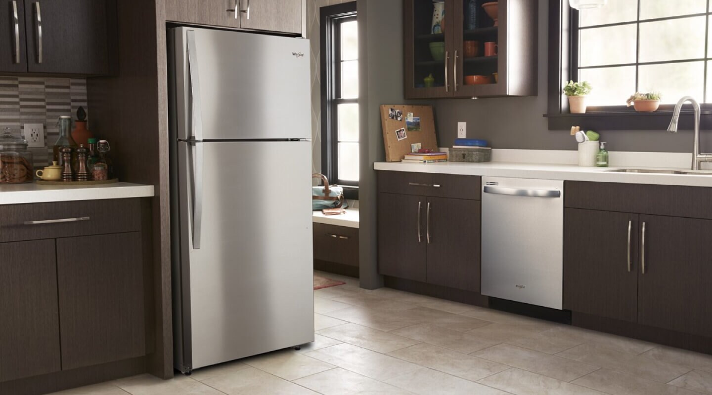 Stainless steel Whirlpool® Top-Freezer Refrigerator in brown cabinetry