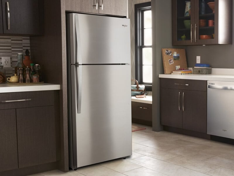 Stainless steel Whirlpool® Top-Freezer Refrigerator in brown cabinetry