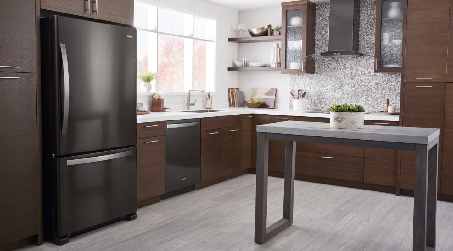 Black Whirlpool® Bottom-Freezer Refrigerator in brown cabinetry
