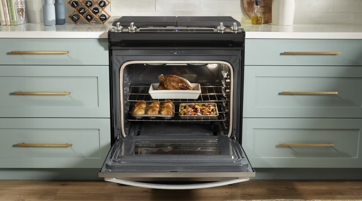 Open gas range cooking several dishes in the oven