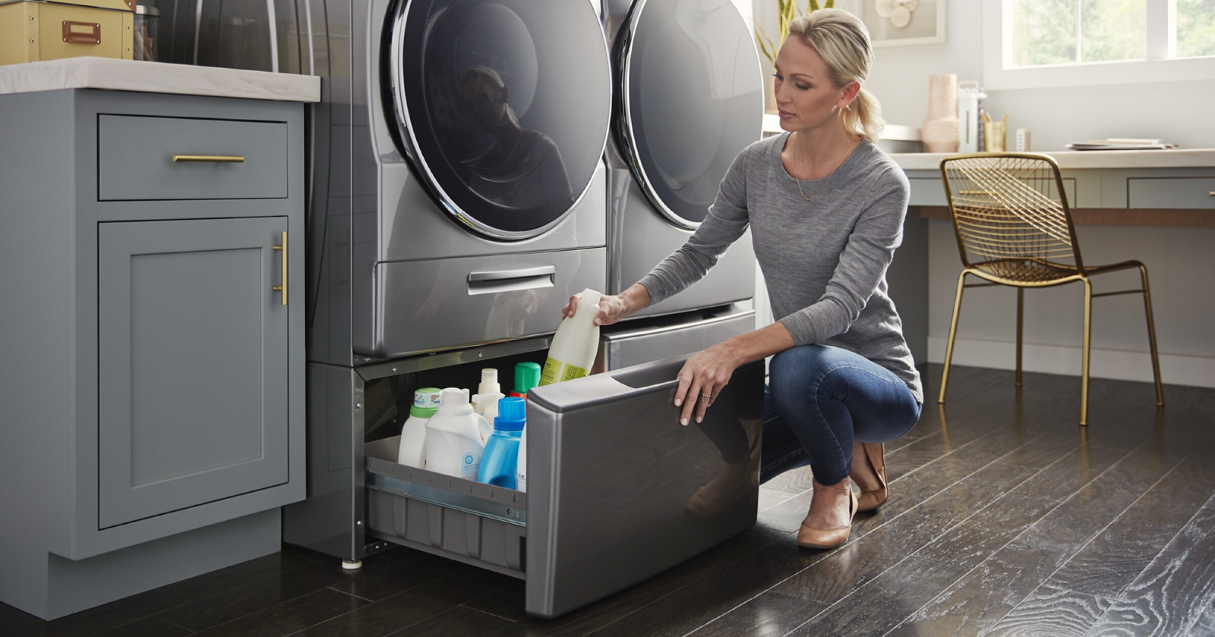 Woman taking cleaning products out of laundry pedestal