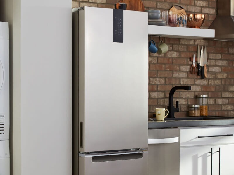 Skinny refrigerator between wall and countertop of small kitchen