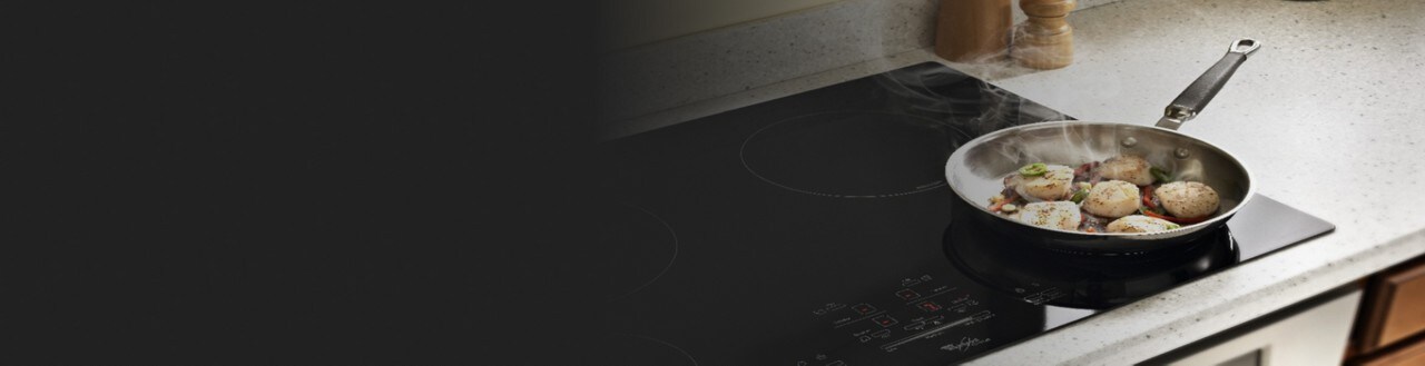 Scallops cooking in a frying pan on a cooktop