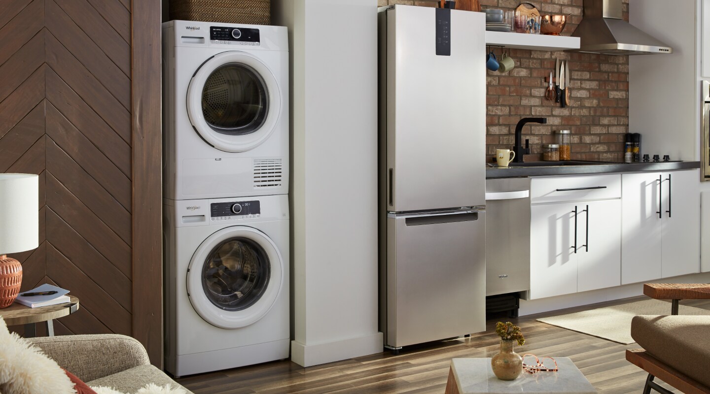 A Whirlpool® stacked washer and dryer in a modern kitchen A Whirlpool® stacked washer and dryer in a modern kitchen