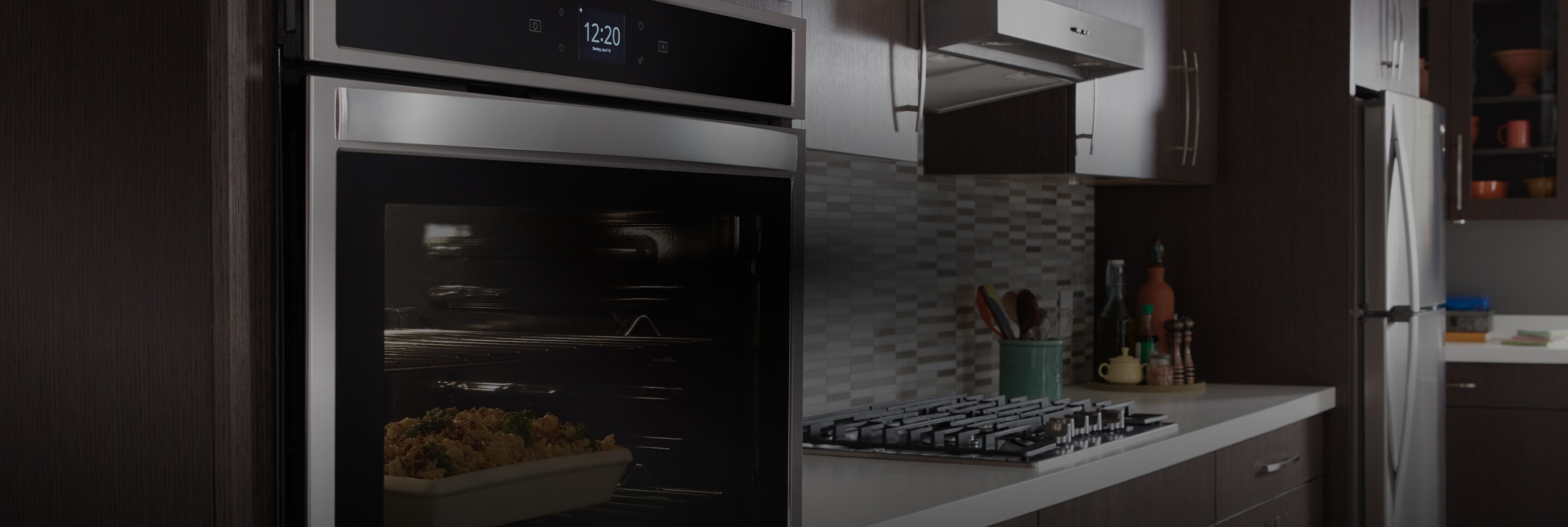 A Whirlpool® kitchen appliance suite featuring the low-profile microwave hood combination.