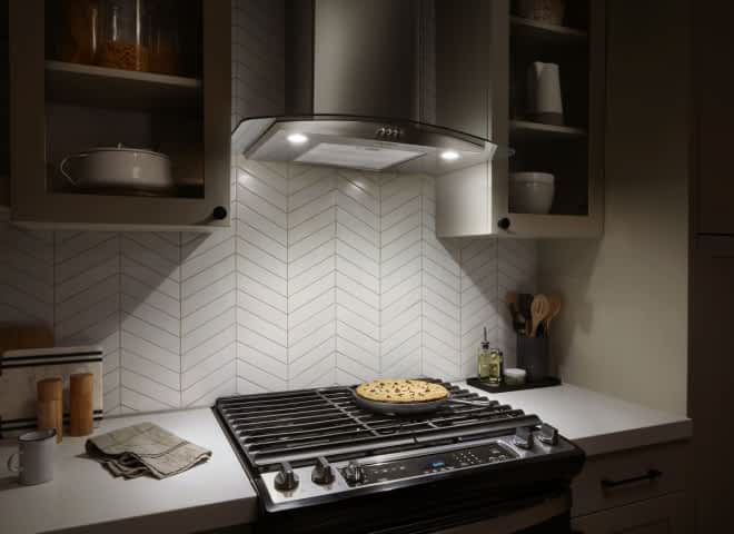 LED Task Lighting from a Whirlpool® Canopy Hood shines down on a cooktop