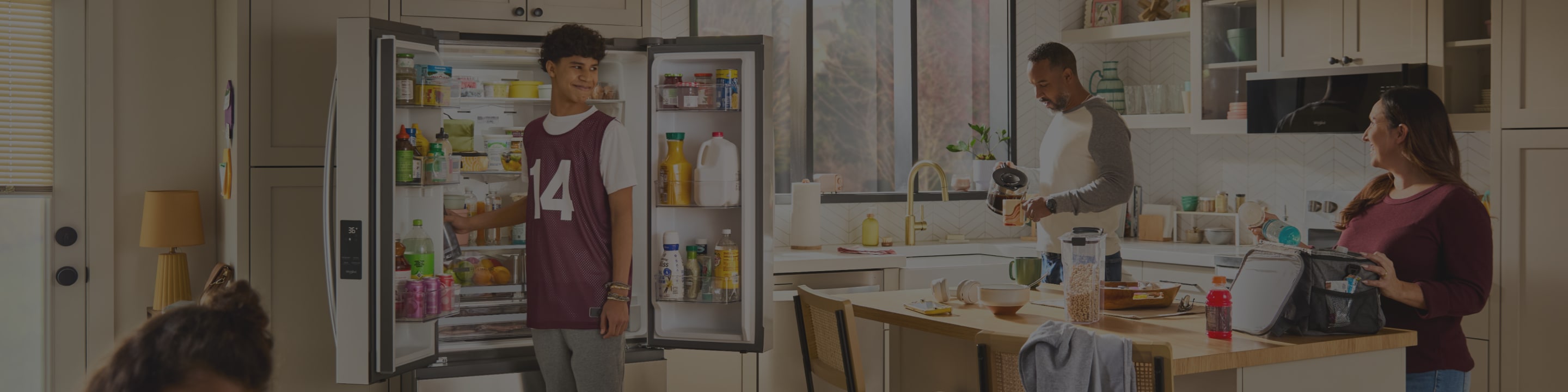 A family removing food from an opened French door refrigerator while preparing lunch