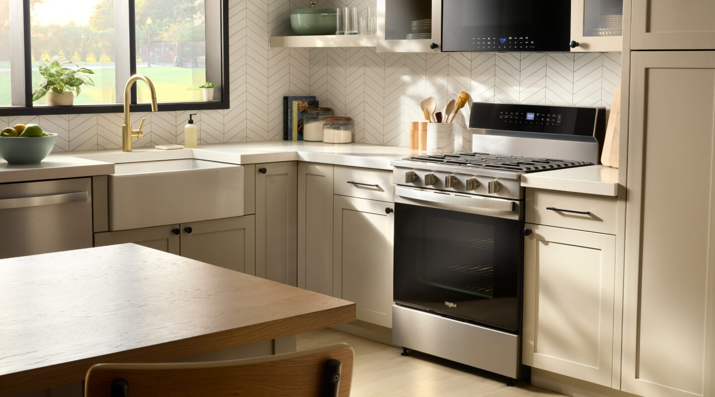 A bright kitchen with a Whirlpool® Gas Range and a microwave