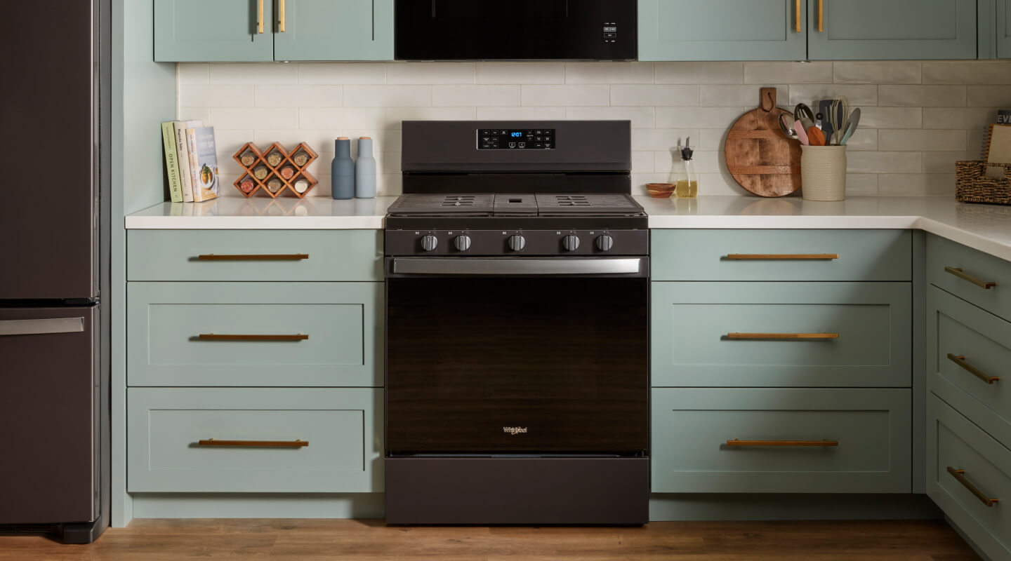 A kitchen with blue cabinetry and a Whirlpool® Gas Range