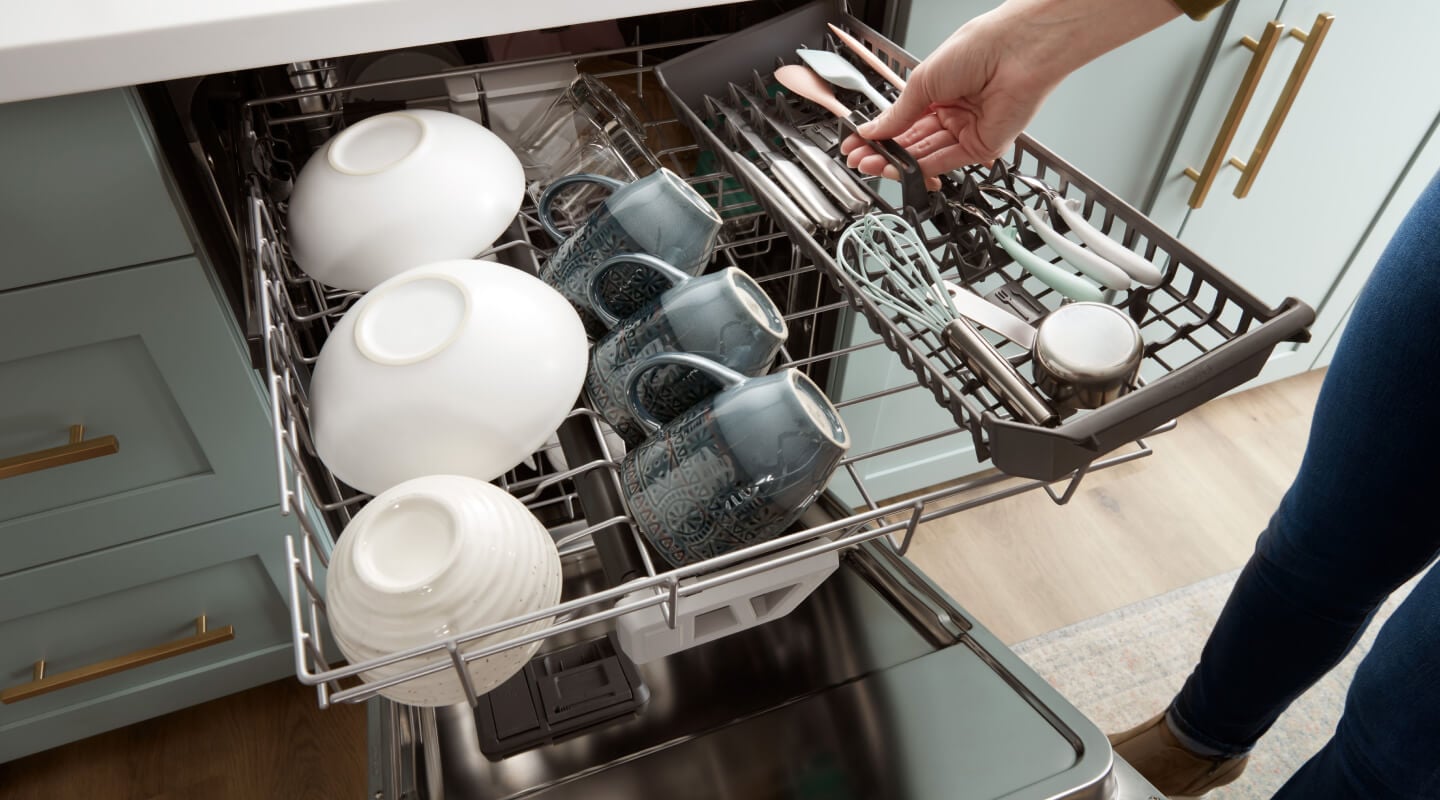 A person loading the third rack of a dishwasher A person loading the third rack of a dishwasher