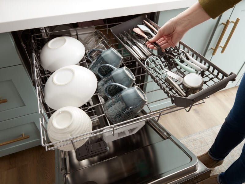 A person loading the third rack of a dishwasher A person loading the third rack of a dishwasher