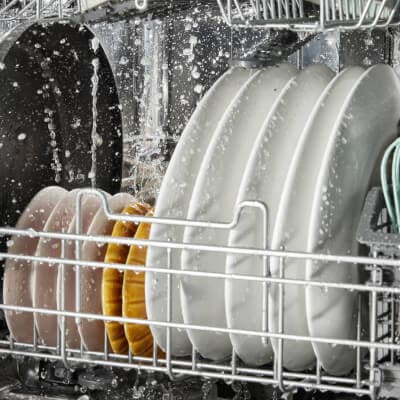 Plates lined up neatly in a dishwasher