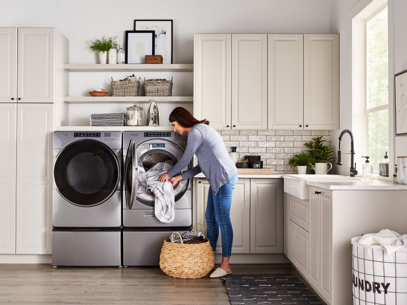 Woman loading laundry in a stainless steel Whirlpool® dryer Woman loading laundry in a stainless steel Whirlpool® dryer