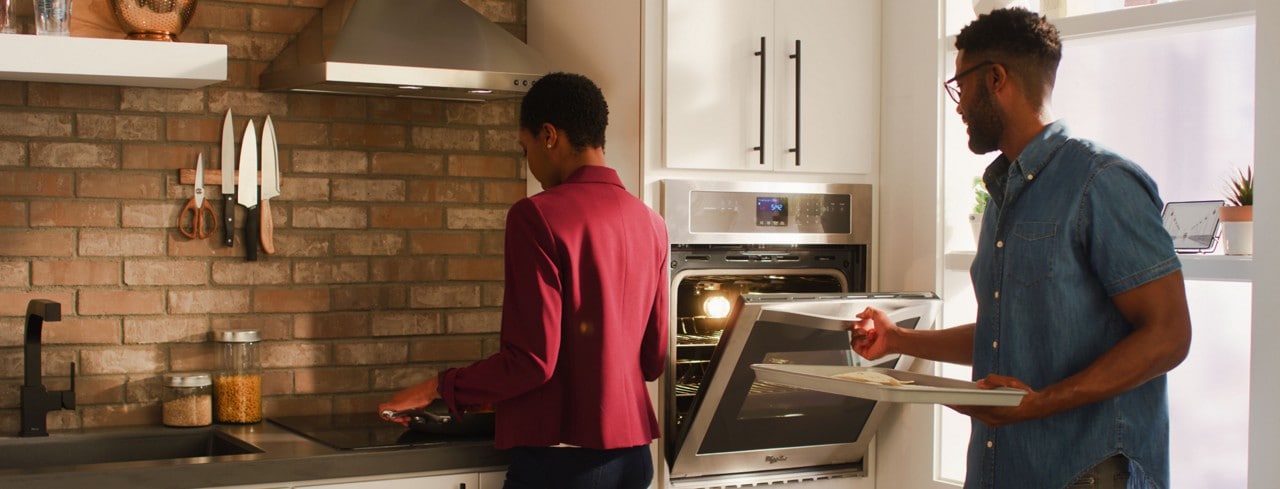 Woman and man cooking together in a kitchen with Whirlpool® small space appliances Woman and man cooking together in a kitchen with Whirlpool® small space appliances