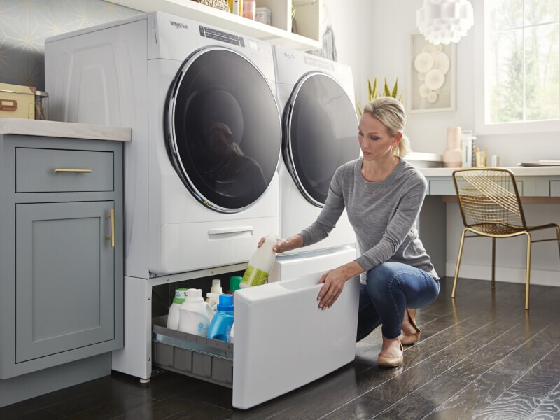 Person putting items away in laundry storage pedestals Person putting items away in laundry storage pedestals