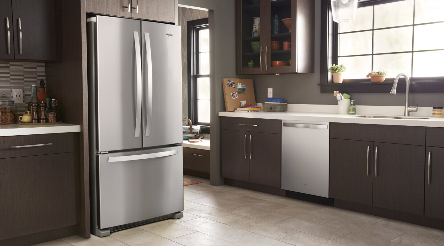 A kitchen with dark cabinetry and a Whirlpool® French Door Refrigerator