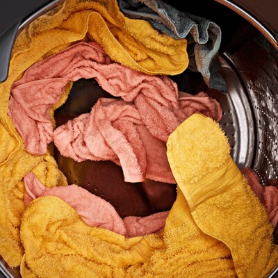 Pink and yellow clothes tumbling in the dryer