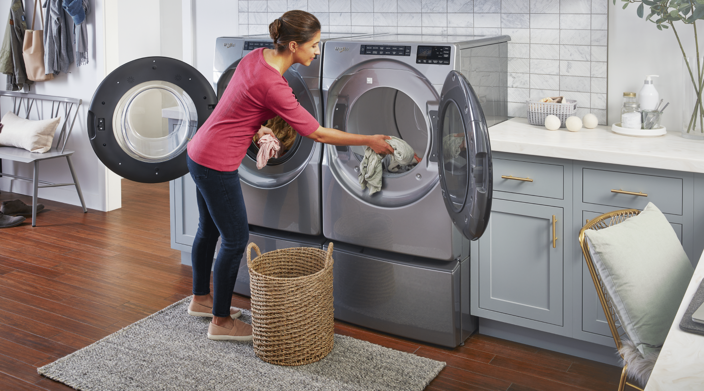 Person loading laundry into a Whirlpool® dryer Person loading laundry into a Whirlpool® dryer