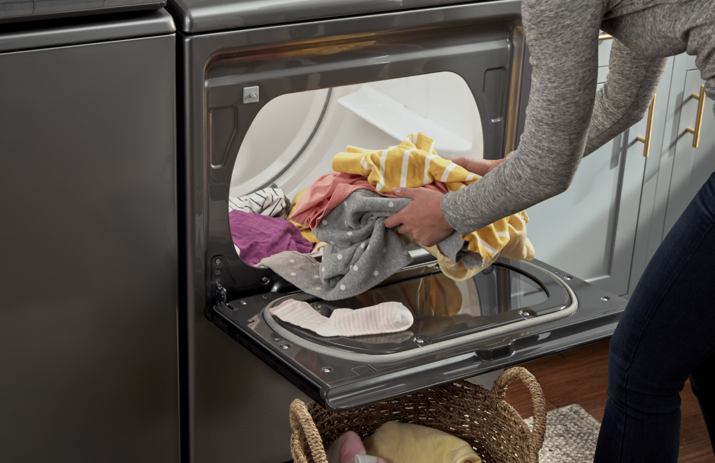 Person loading clothes into a Whirlpool® dryer Person loading clothes into a Whirlpool® dryer