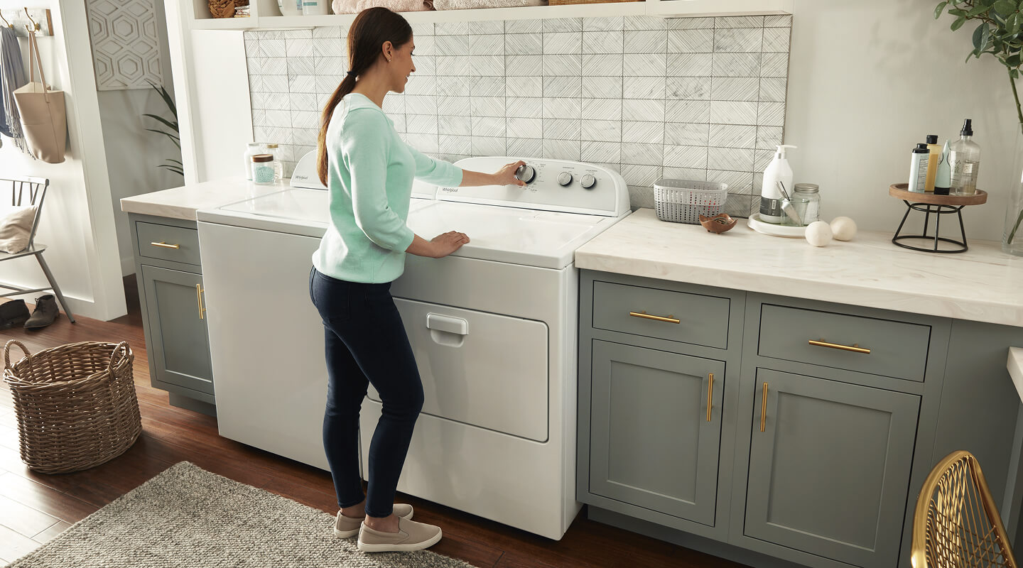 Person selecting a cycle setting on a Whirlpool® dryer