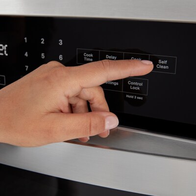 A person selecting the Self Clean option on an oven