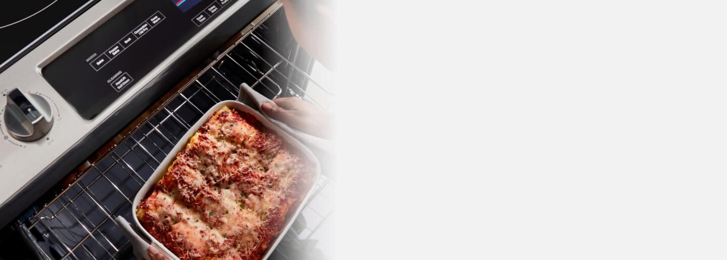 Person removing a casserole dish from an oven