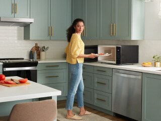 Person standing in front of a countertop microwave