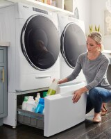 Person pulling items out of a laundry pedestal drawer