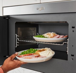 A person reheating leftovers in a microwave