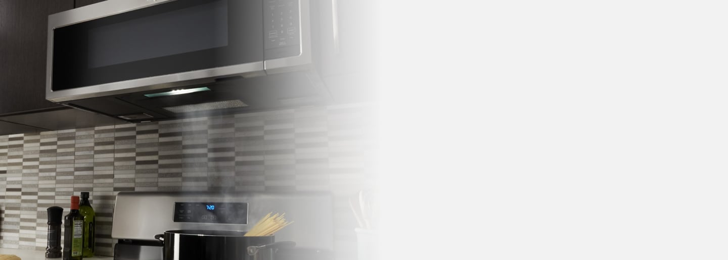 Range hood over a stove with a pot of boiling water