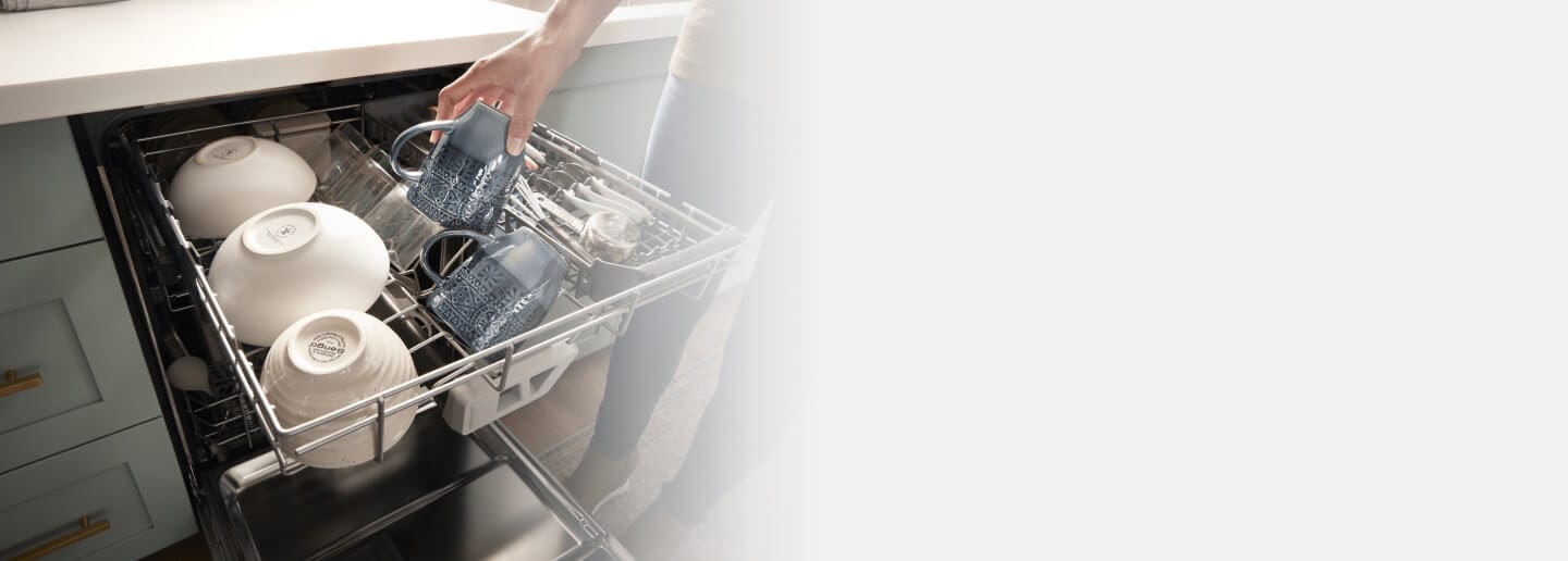 Dishes being placed inside a Whirlpool® Dishwasher with 3rd Rack