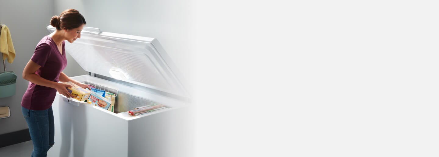 Person loading food into a chest freezer