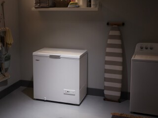 A white chest freezer in a garage