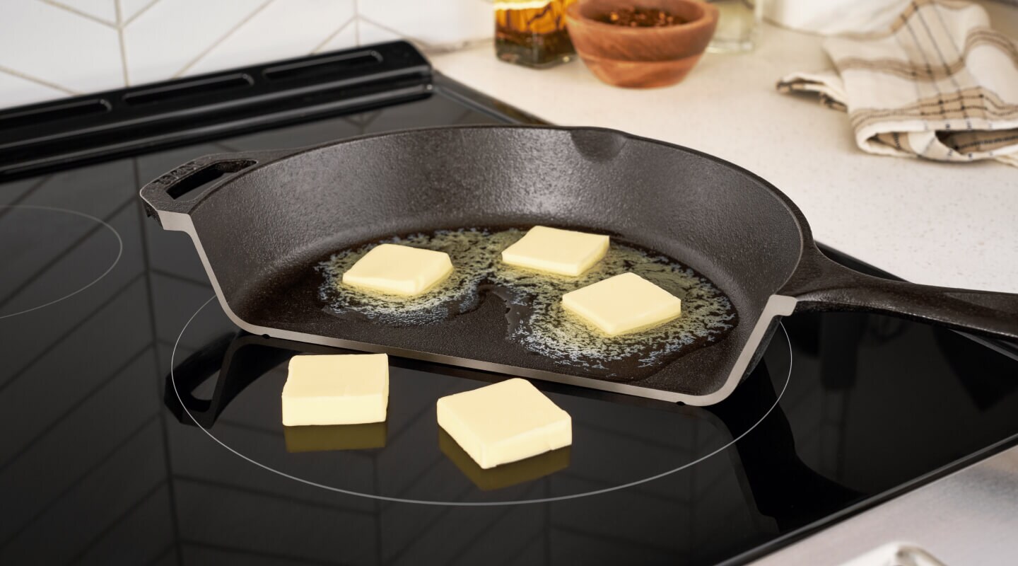 Photo of half a pan on a stove with butter melting on it, and next to it, non-melting pads of butter on the cooktop Photo of half a pan on a stove with butter melting on it, and next to it, non-melting pads of butter on the cooktop