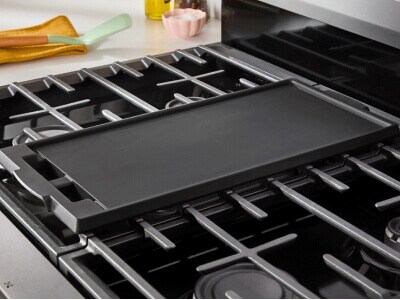 A griddle pan shown inset onto an otherwise empty stovetop on a range