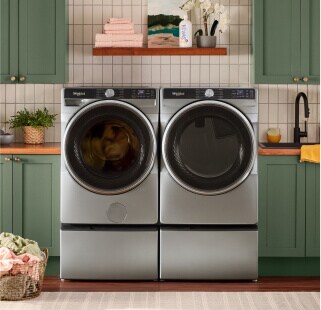 A Whirlpool® Washer and Dryer Set surrounded by green cabinetry