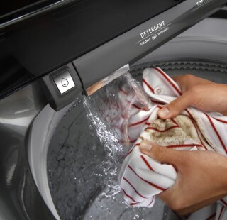 A person pre-treating a towel