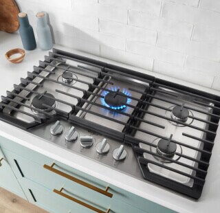 A cooktop with a blue flame simmering