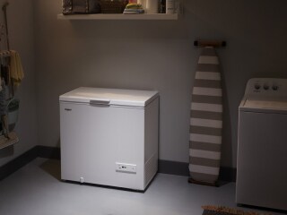 A white chest freezer in a garage