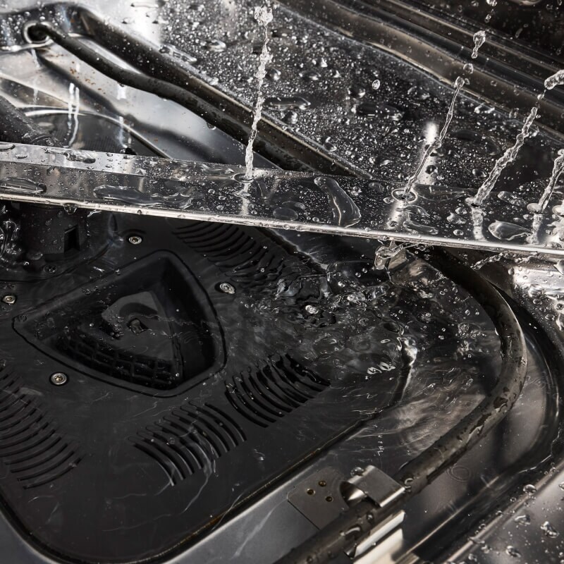 Closeup of dishwasher spray arm spraying water