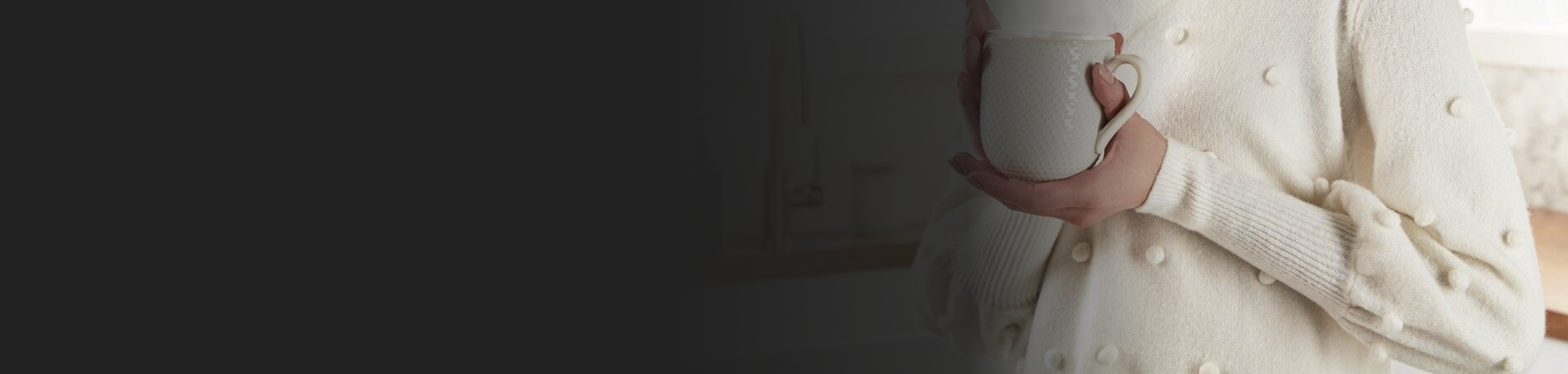 Person in a white sweater holding a white mug