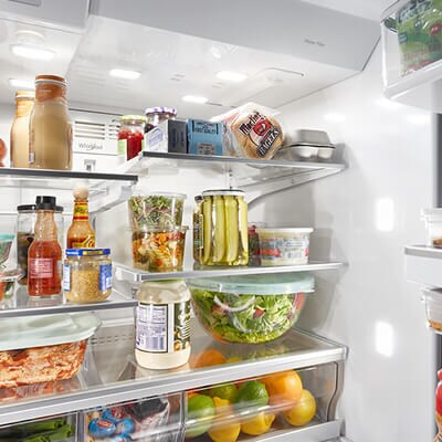 Fresh food and condiments stocked in refrigerator compartment