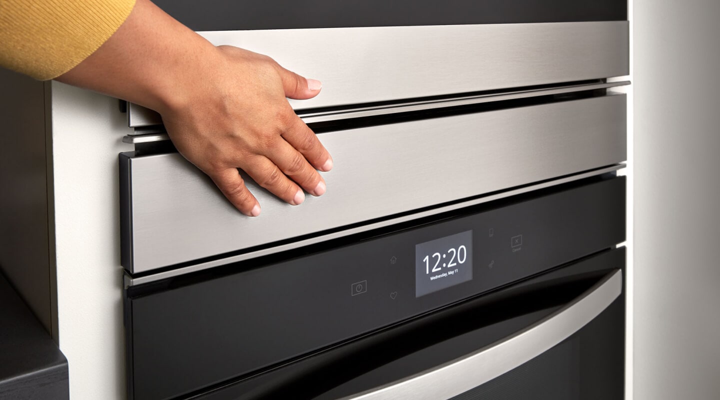 Hand touching a Whirlpool® double wall oven Hand touching a Whirlpool® double wall oven