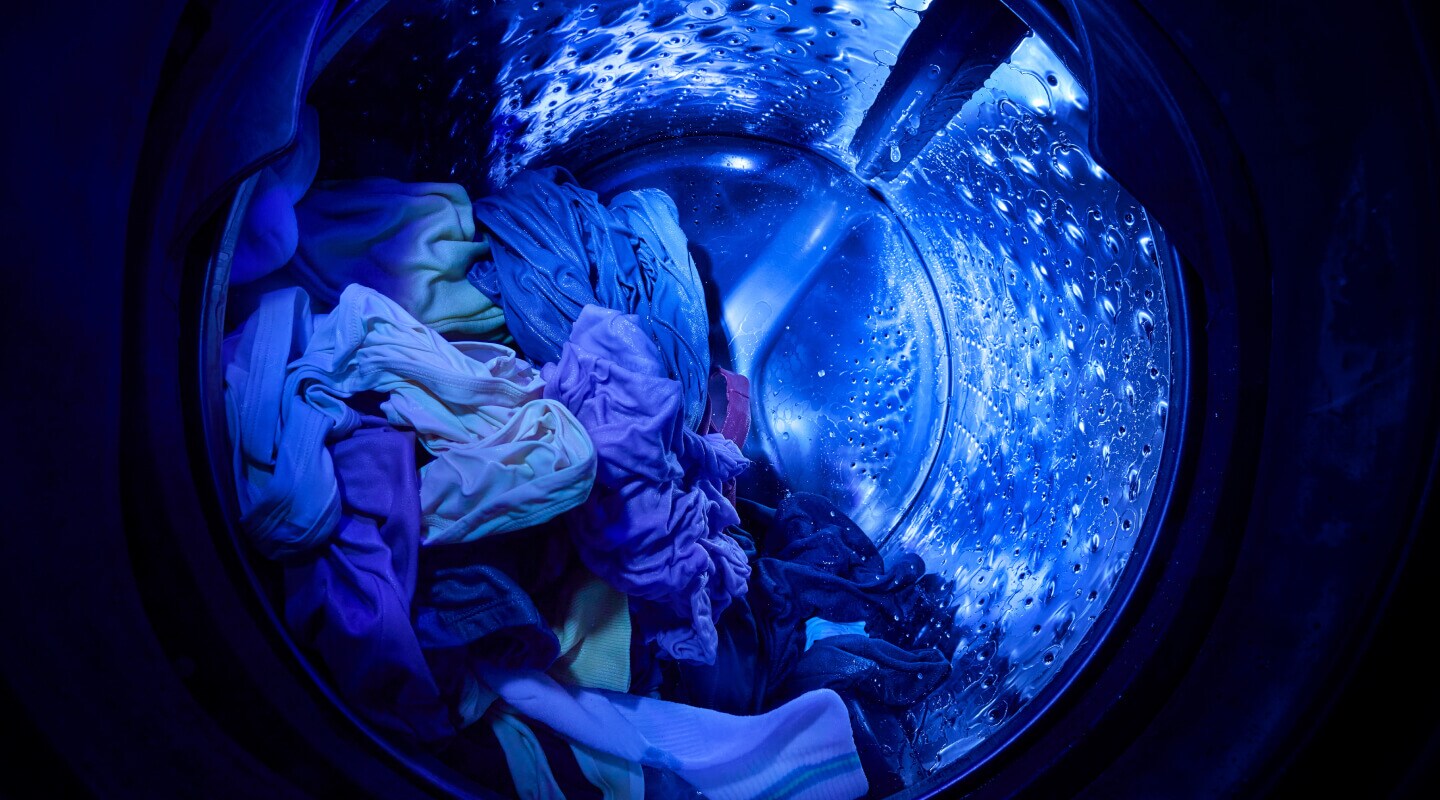 UV cleaning technology shining a blue light inside a wash basket with clothes
