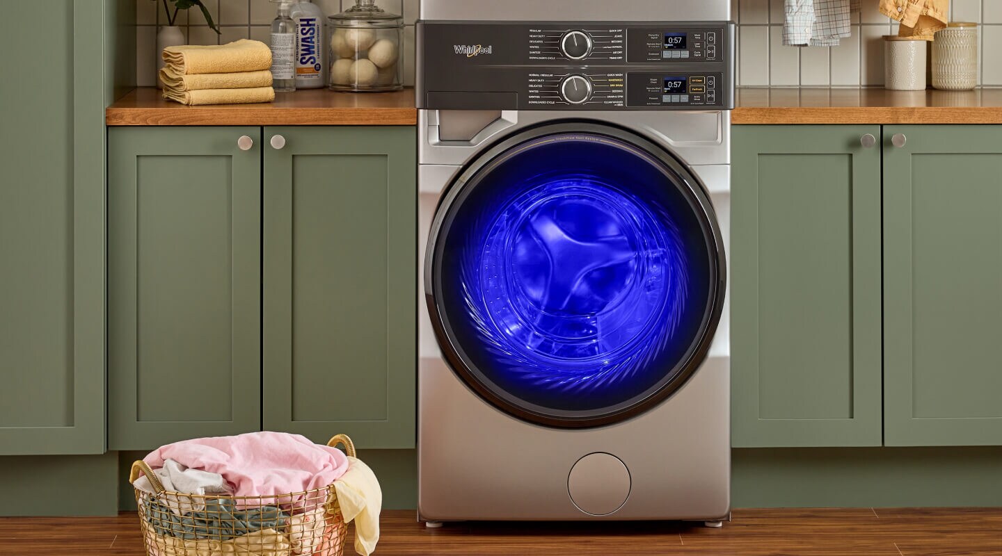 Blue UV lighting shining inside a Whirlpool® Front Load Laundry Tower washer