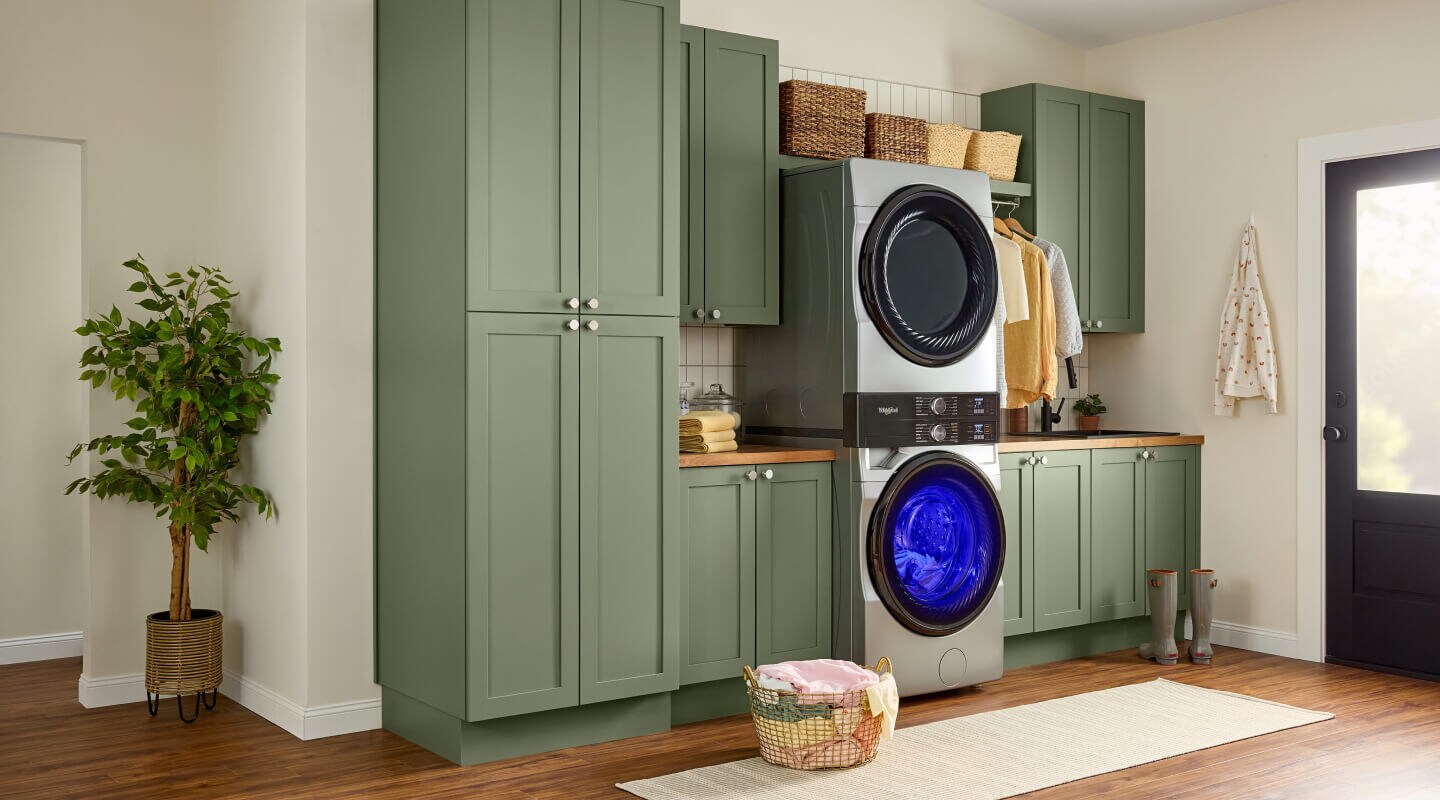 Whirlpool® Front Load Laundry Tower in open laundry room with green cabinetry