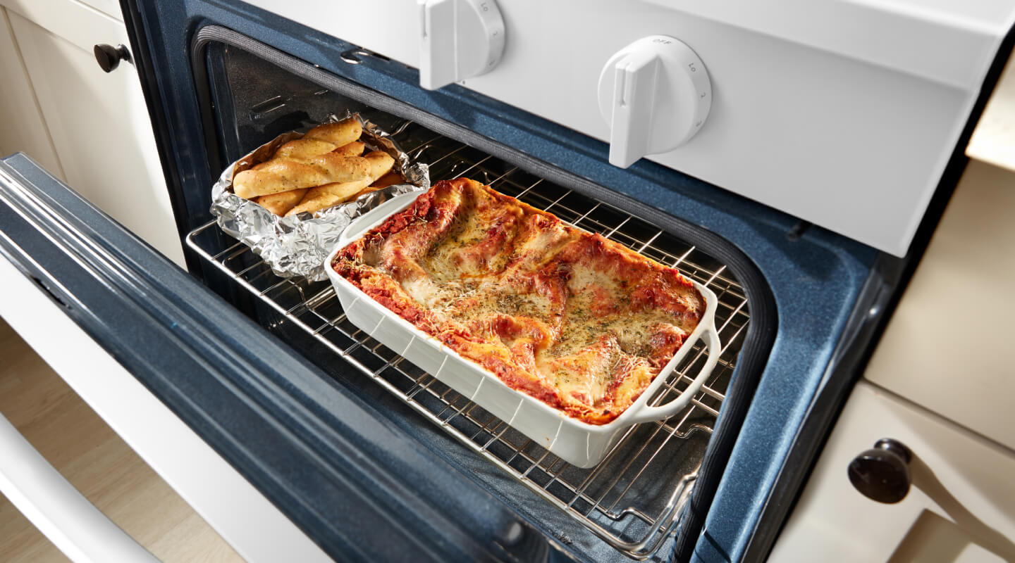 Casserole and breadsticks in an oven